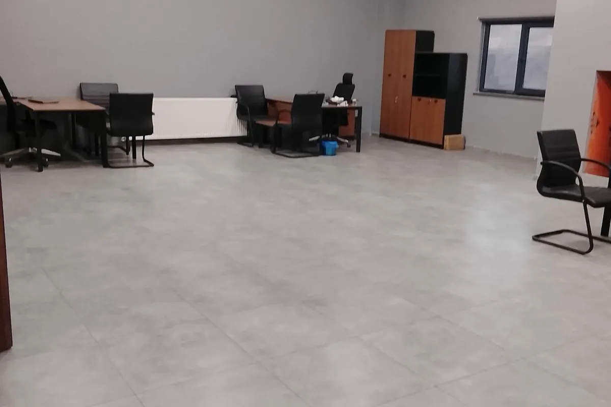 Temizlik sonrası Diyarbakır'daki ofiste çalışma masaları ve geniş seramik zemin