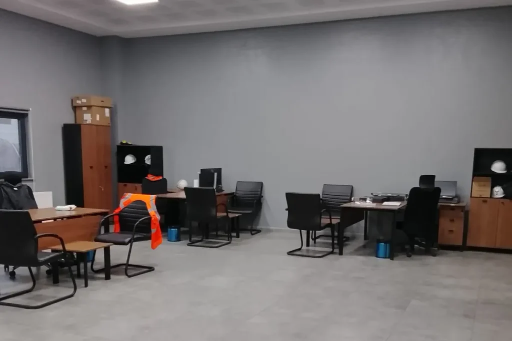 Diyarbakır'da temizlenmiş şantiye saha ofisi, baretler ve ahşap ofis mobilyaları
